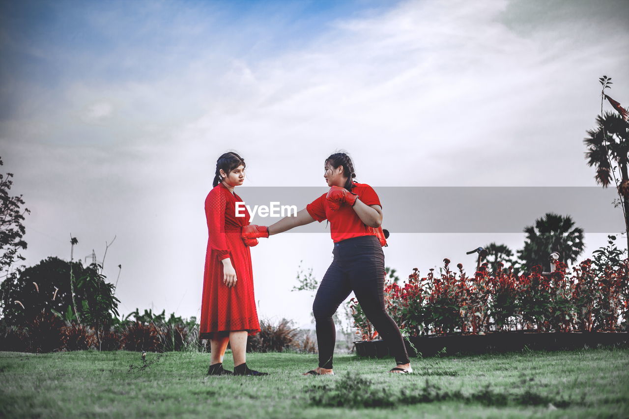Beautiful two chubby teens exercise with muay thai or thai boxing in red clothes against covid 19