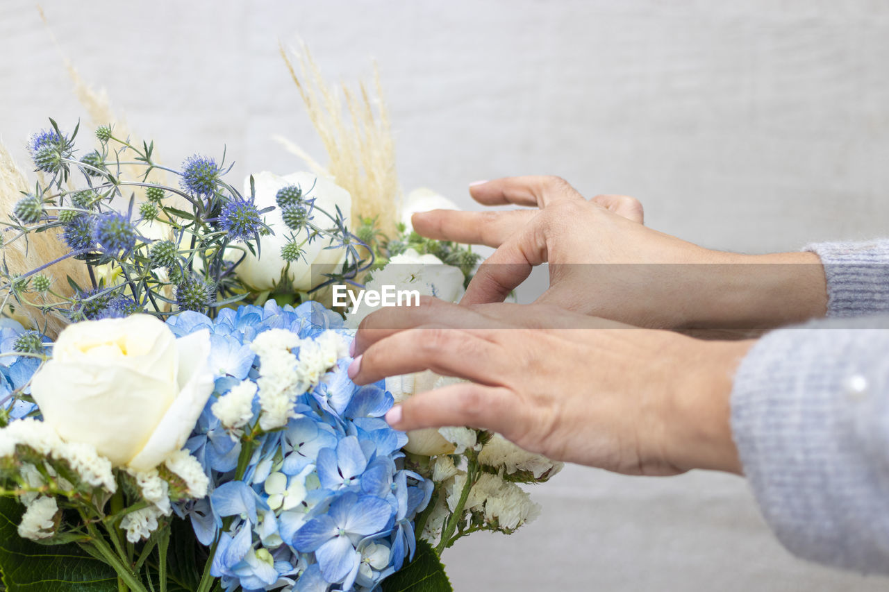 Cropped hands of florist decorating bouquet in flower shop