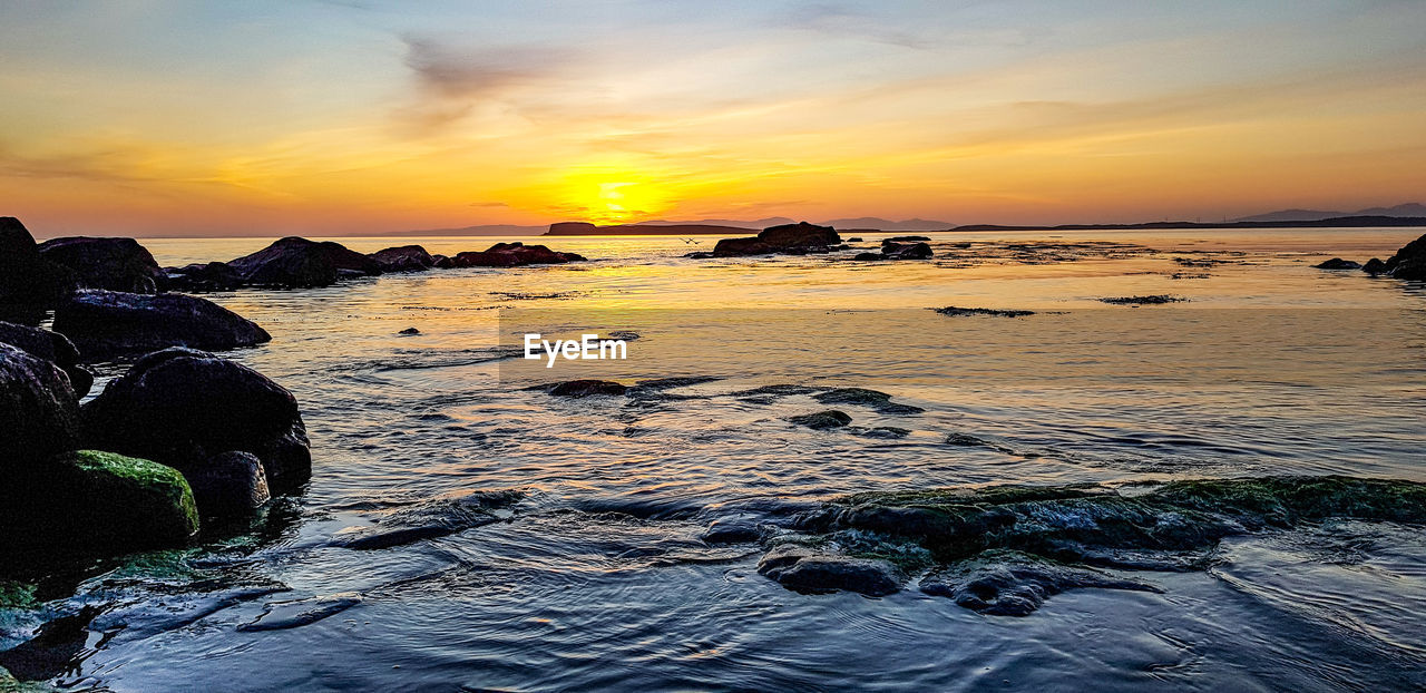 SCENIC VIEW OF BEACH DURING SUNSET