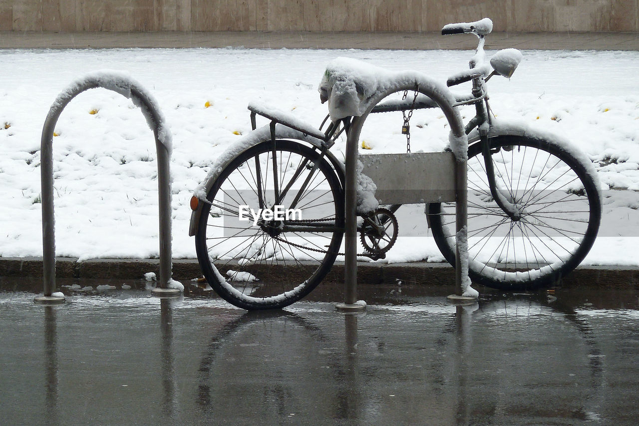 Bicycle covered with snow on the street during  season