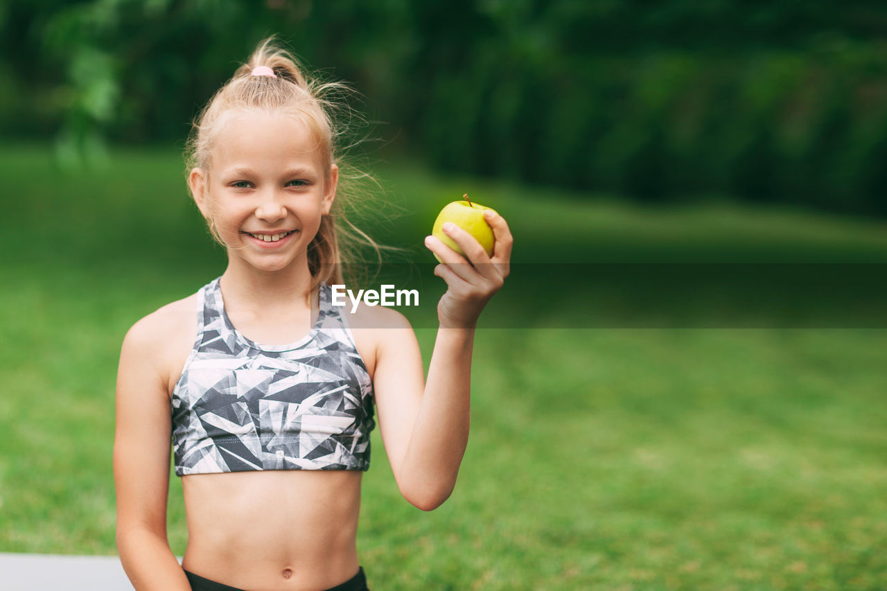 Girl eating apple on field