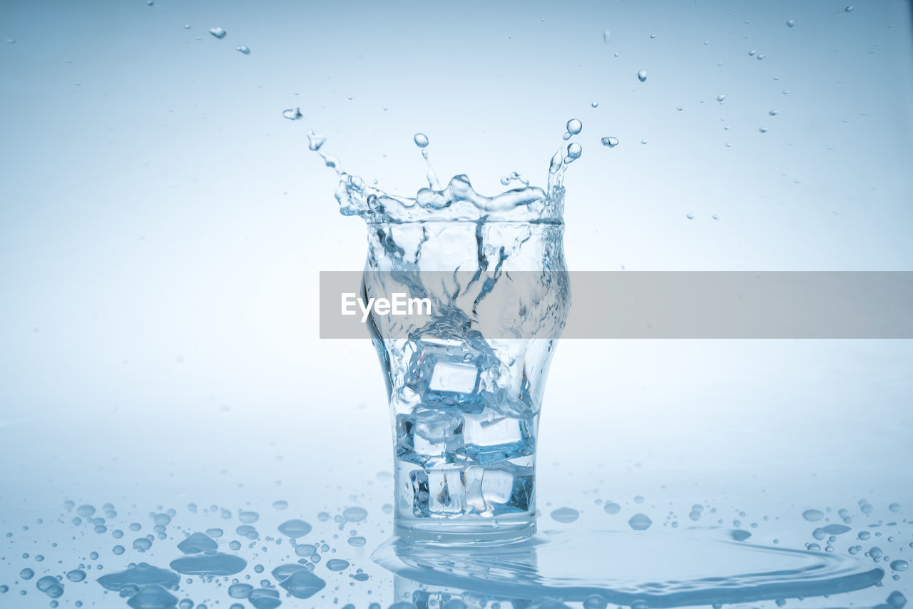 water, splashing, drop, motion, studio shot, nature, blue, food and drink, no people, indoors, refreshment, freshness, freezing, wet, transparent, impact, drink, falling, purity, ice, colored background, bubble, close-up, drinking glass, drinking water, abstract, simplicity