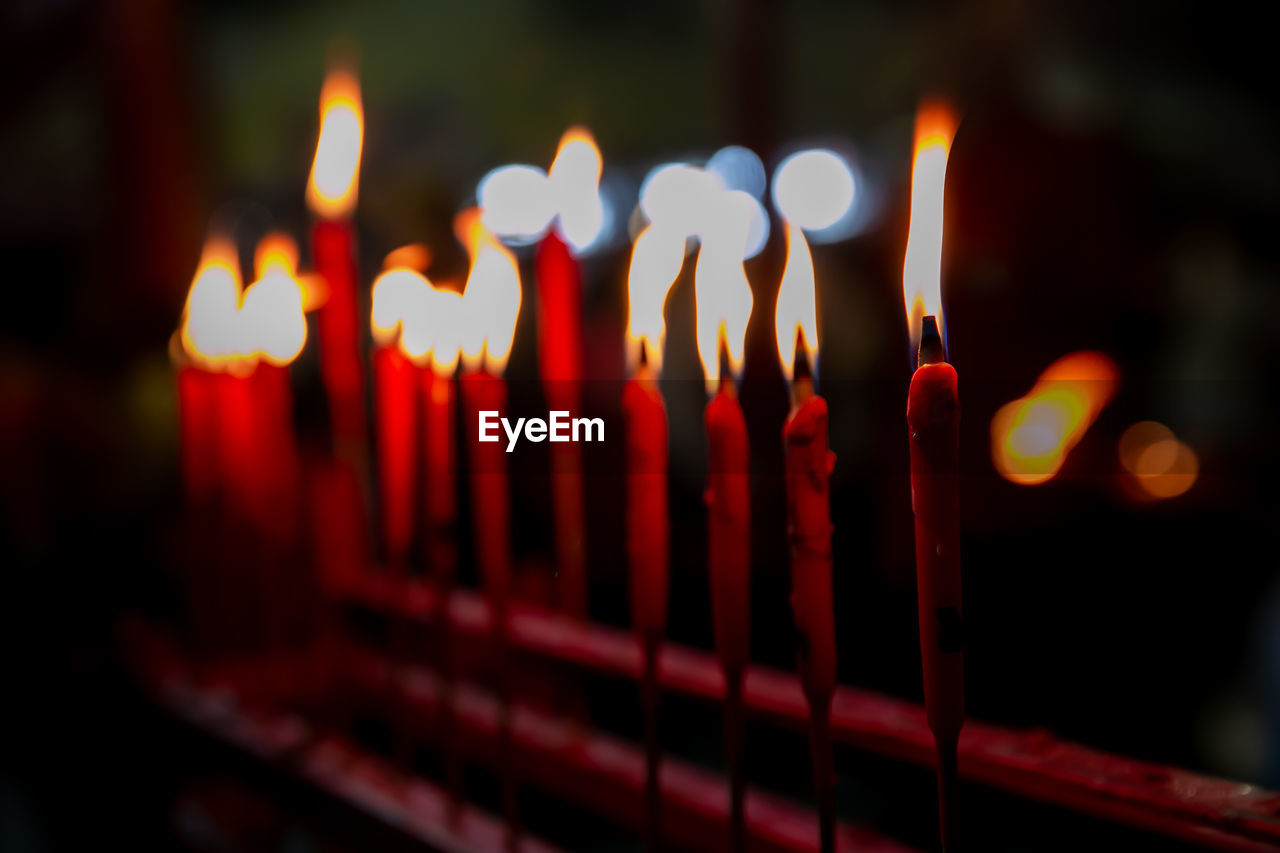 Close-up of lit candles in temple