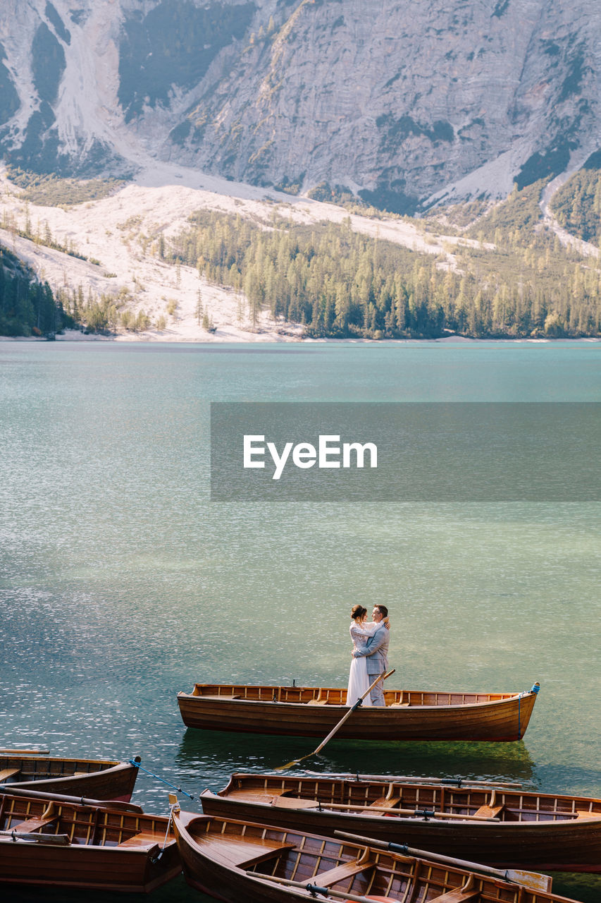 MAN STANDING ON BOAT IN LAKE