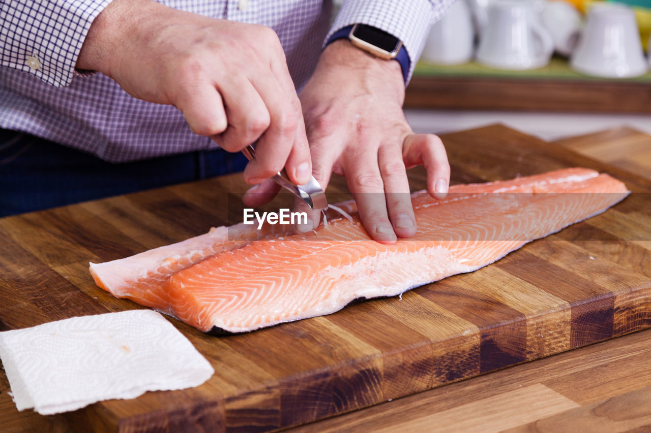 Cropped image of man cleaning fish