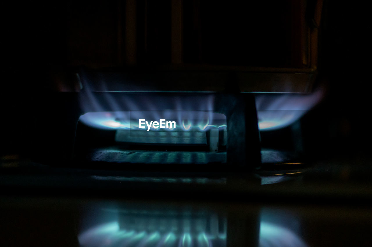 darkness, light, heat, appliance, stove, fire, burning, indoors, kitchen, burner - stove top, flame, power generation, reflection, domestic room, lighting, no people, black, natural gas, close-up, blue, technology, household equipment, domestic kitchen, fossil fuel, gas stove, dark, illuminated, home appliance, oven, home