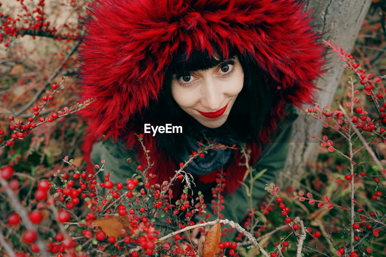 Woman wearing fur coat amidst red berries