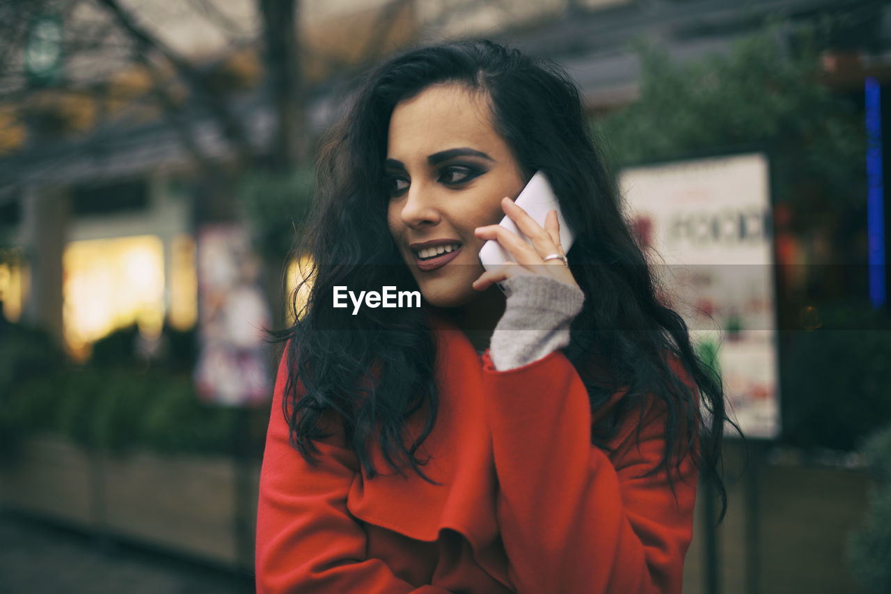 Young woman talking on mobile phone in city