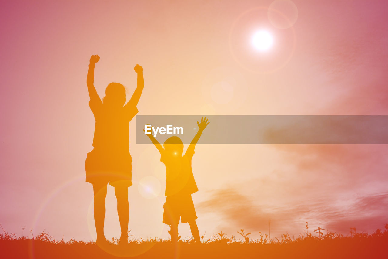 Low angle view of woman hands against sky during sunset