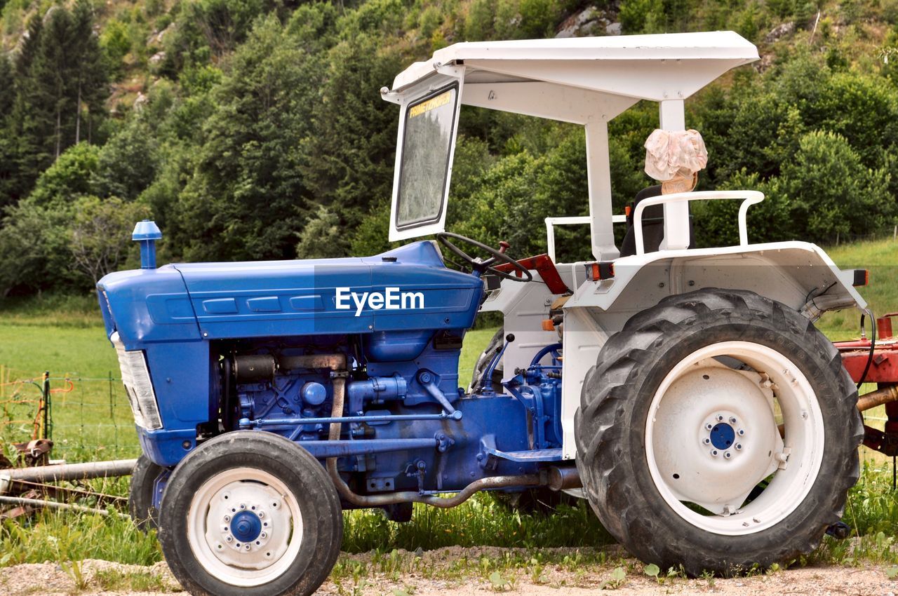 Side view of abandoned tractor on field