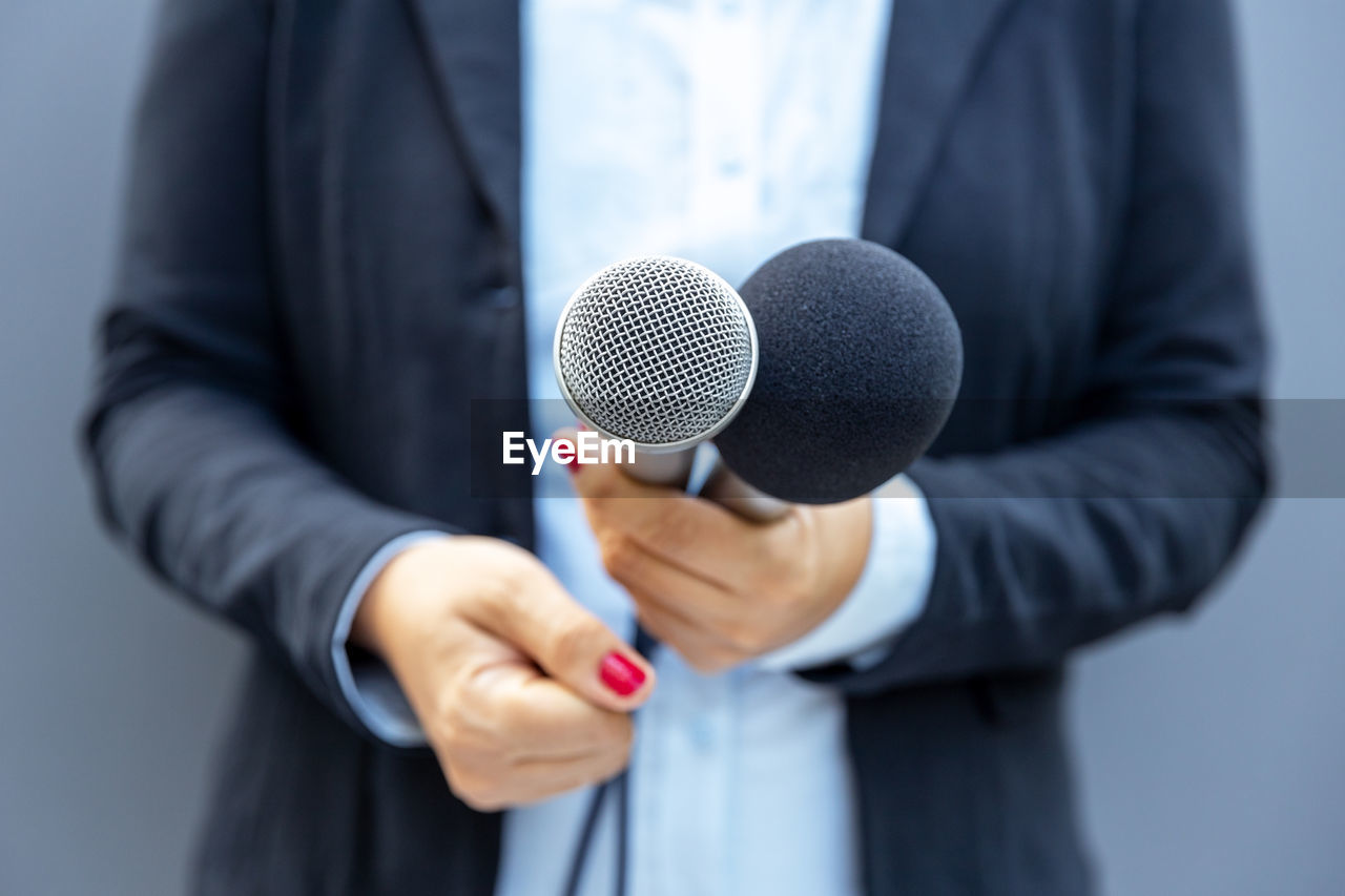 Television reporter holding microphone during press interview. journalism concept.