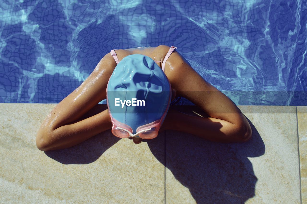 High angle view of girl sitting in swimming pool