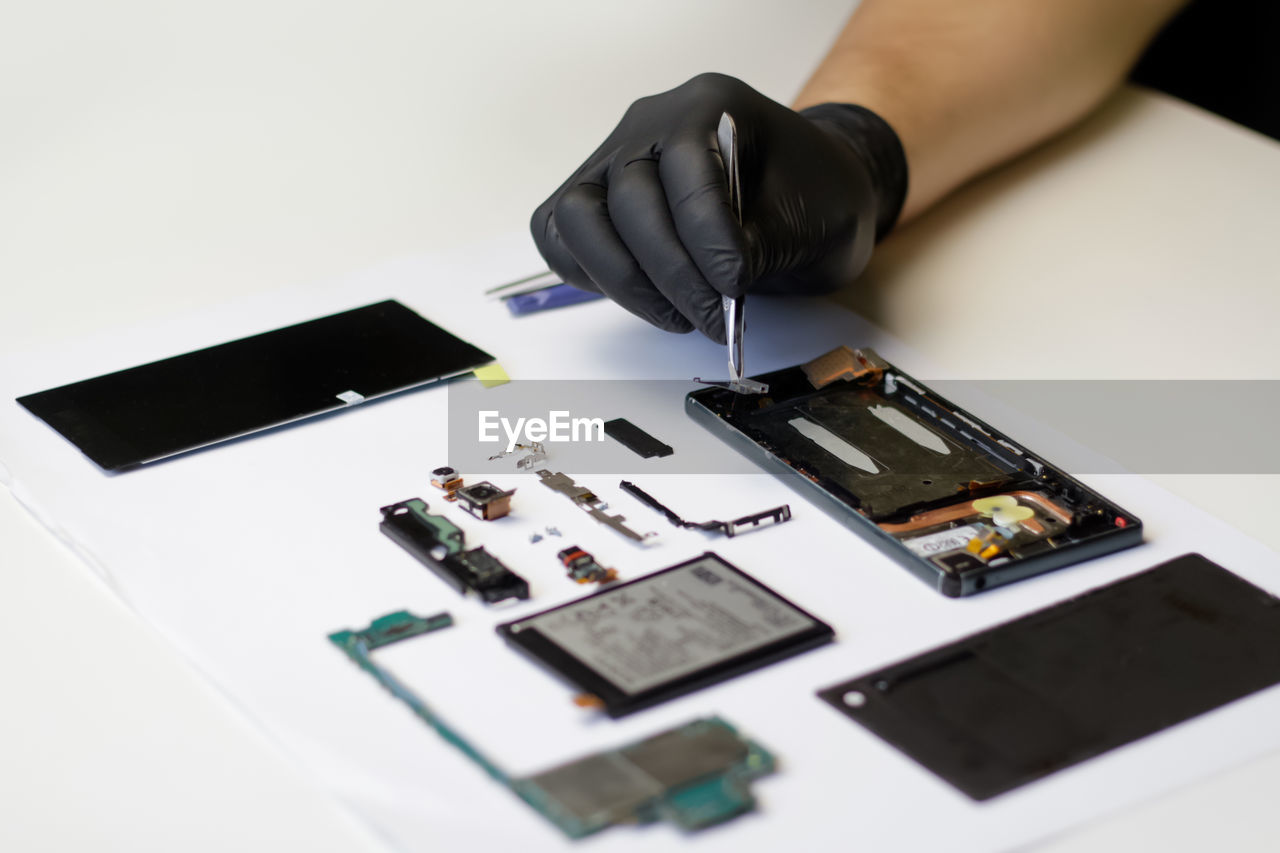 Technician repairing the smartphone's motherboard in the lab. mobile phone, electronic, repairing