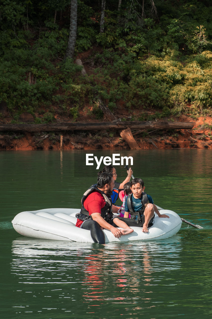 Man with children floating on lake