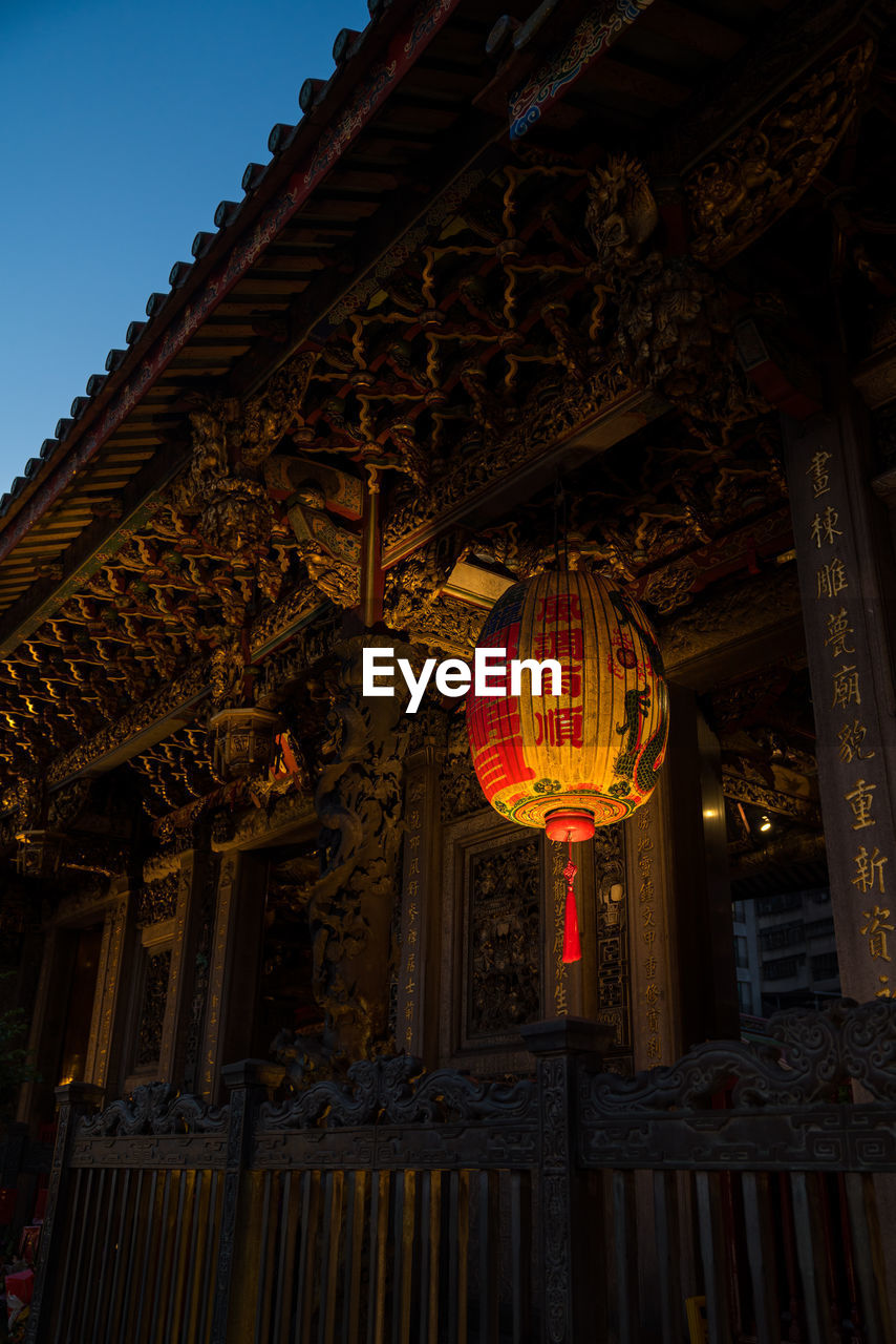 Low angle view of lantern hanging against building