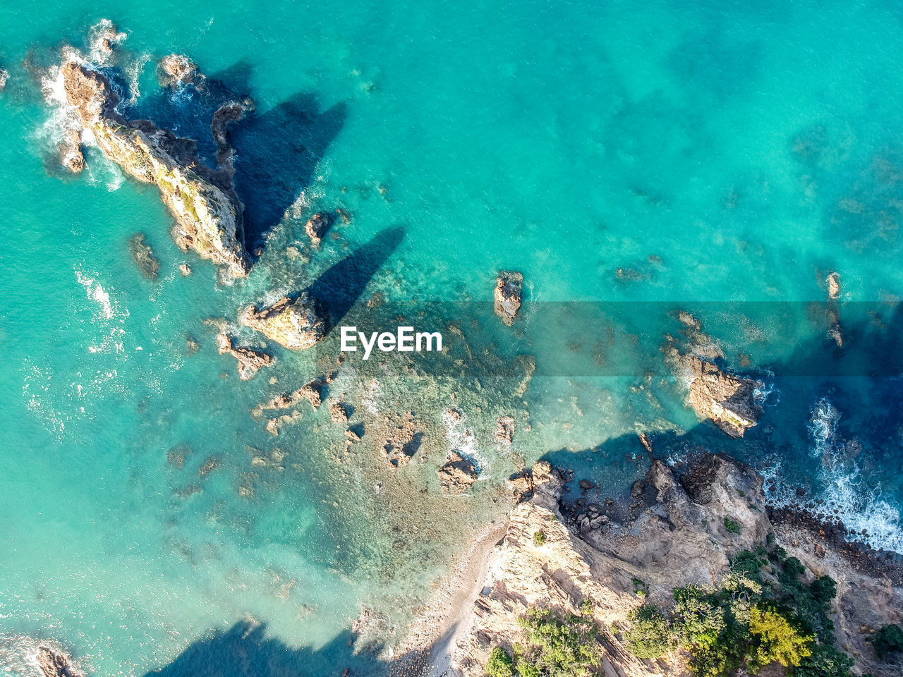 Drone view of rocks in the water at otama beach near matarangi, coromandel peninsula in new zealand.