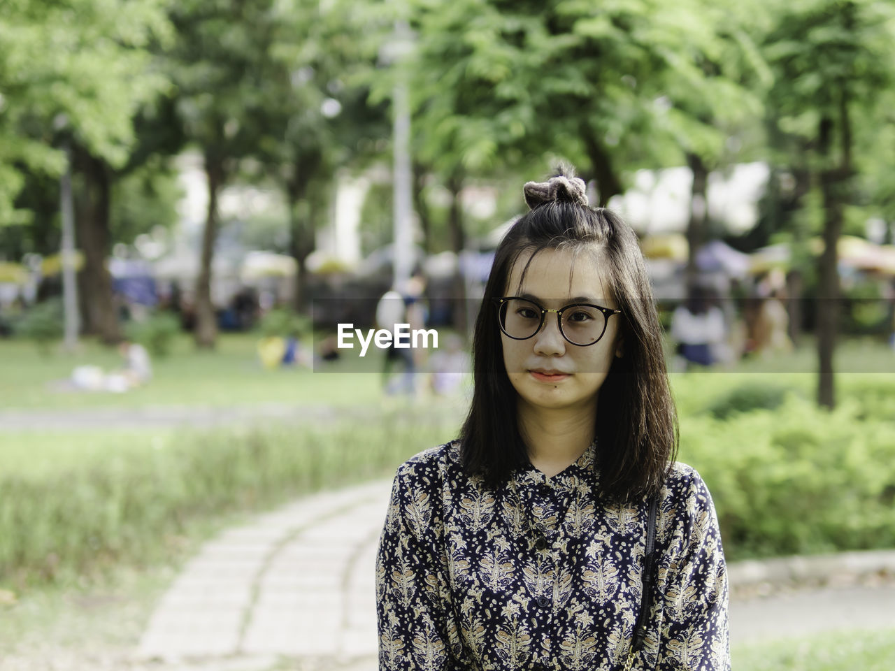 Portrait of young woman in eyeglasses standing outdoors