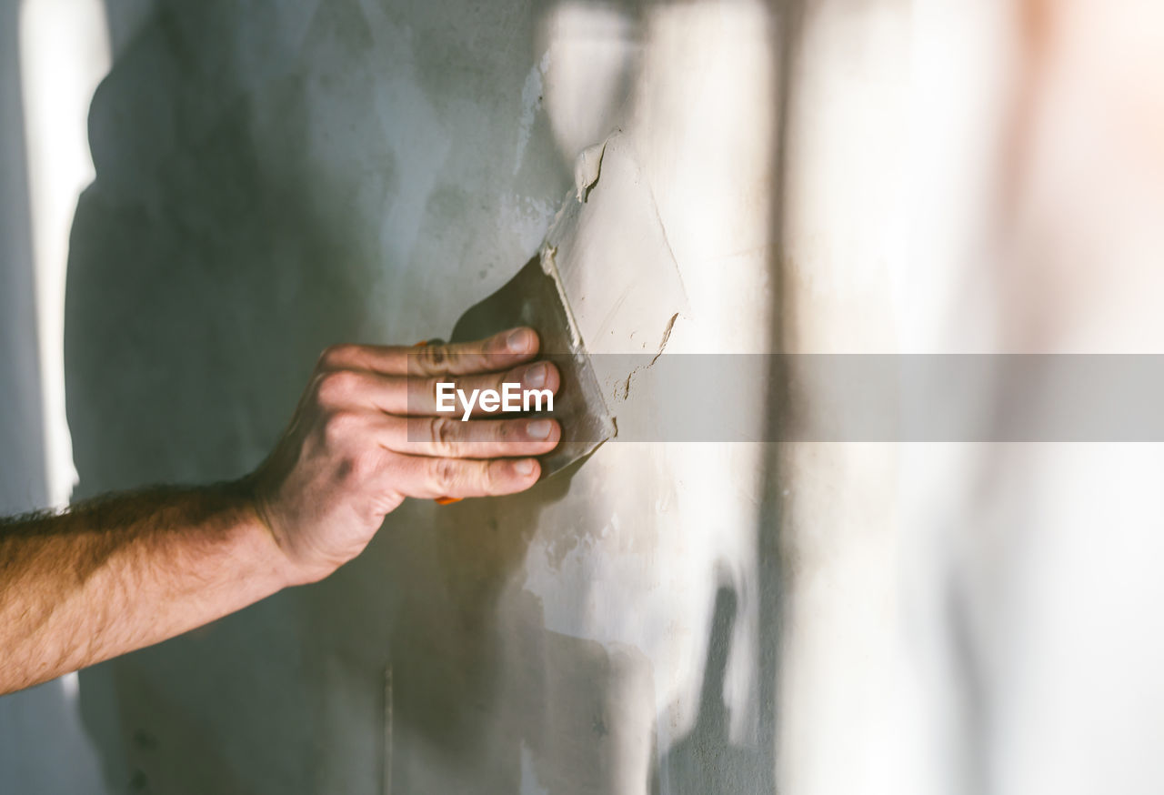 Cropped hand of worker plastering wall