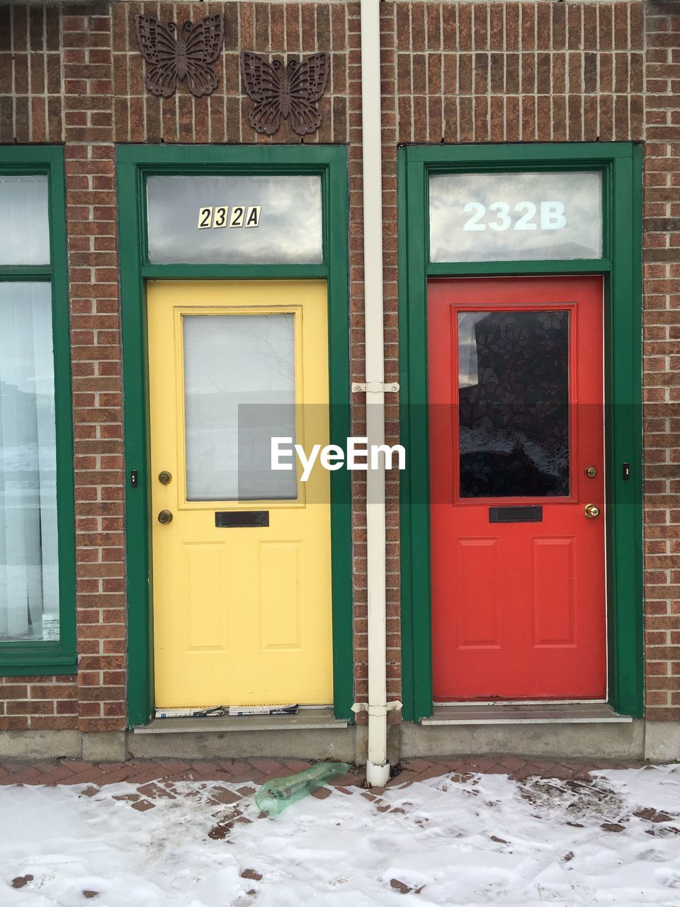 Closed red and yellow doors on brick wall