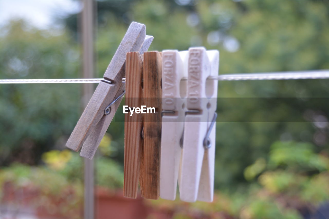 Close-up of pegs on washing line against blurred background