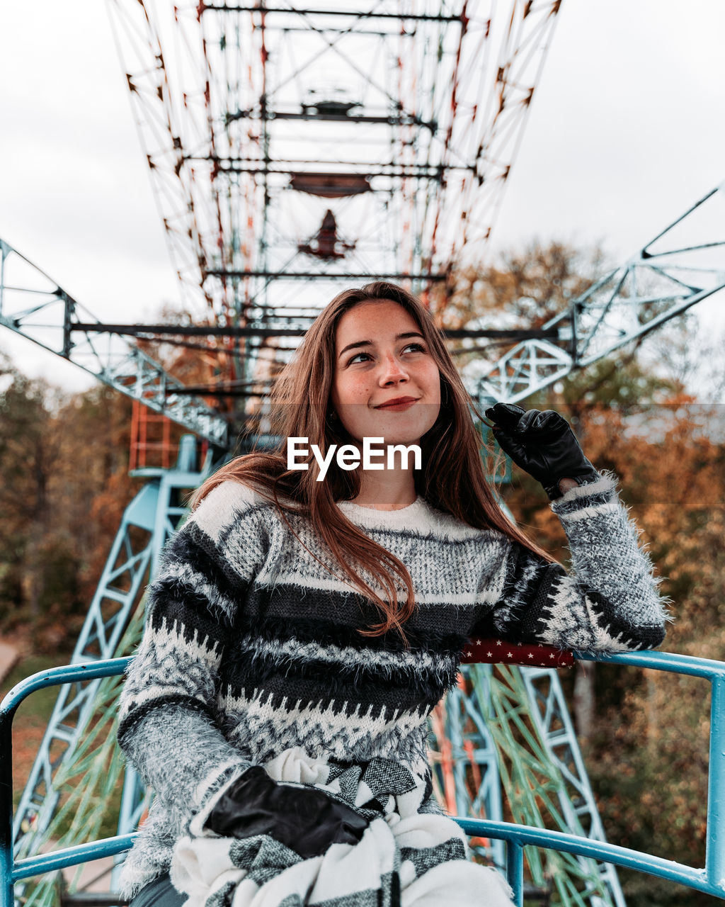 Smiling young woman sitting on ferris wheel