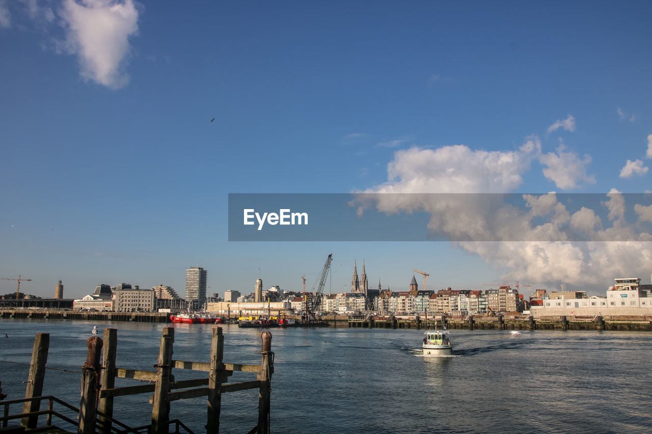 SEA BY BUILDINGS AGAINST SKY