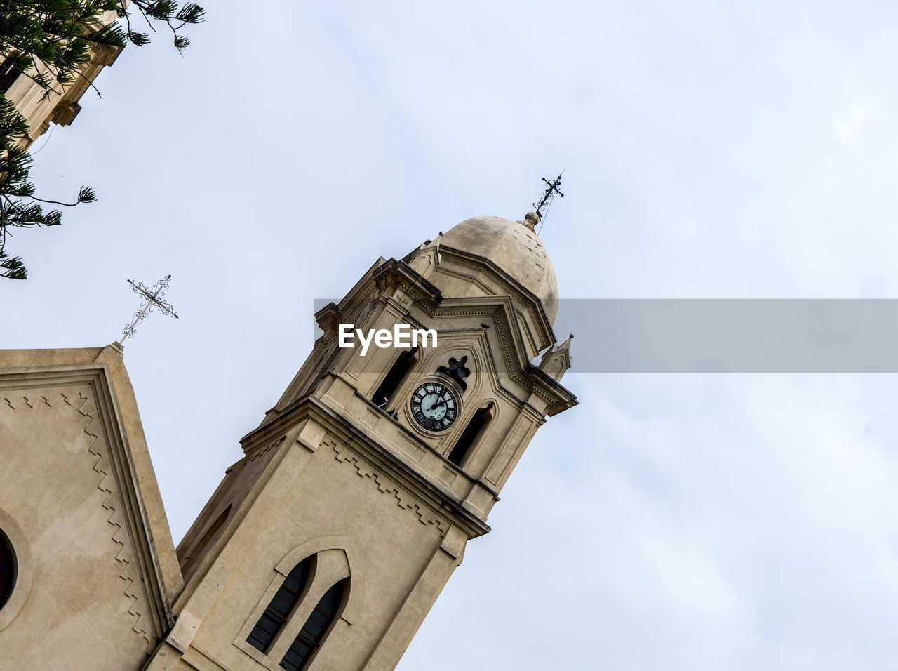 Low angle view of clock tower amidst buildings against sky