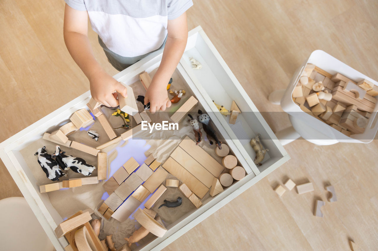 high angle view of woman standing by toy blocks on table