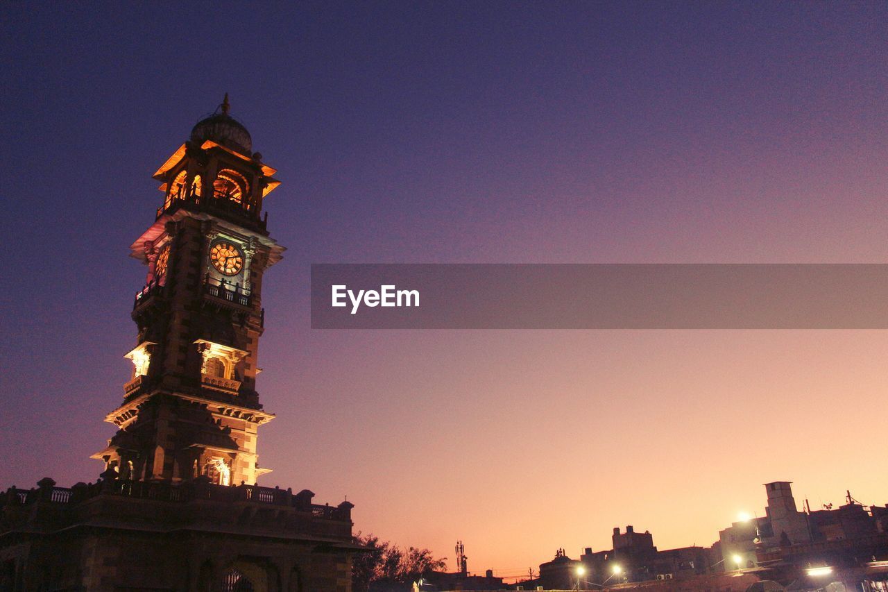 Low angle view of illuminated building against sky during sunset