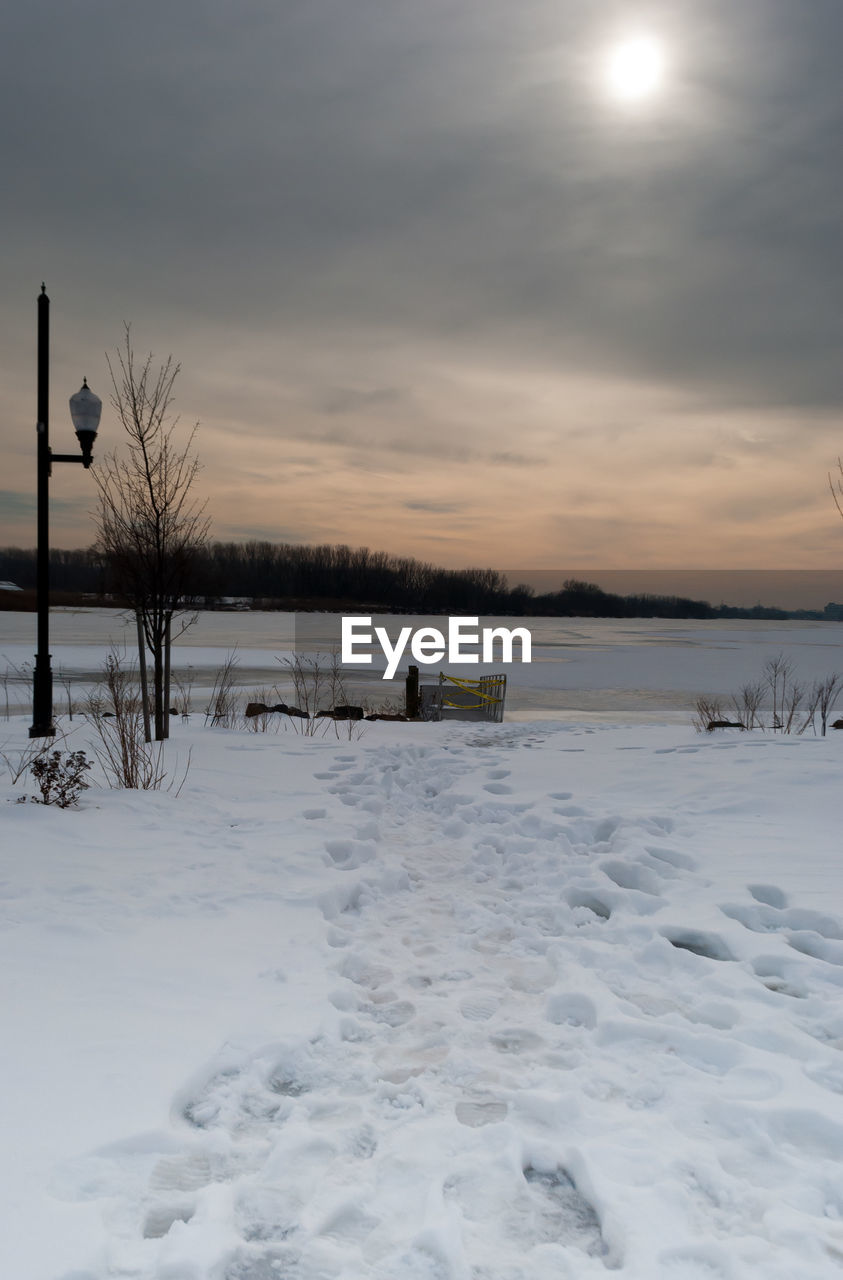 SCENIC VIEW OF FROZEN LAKE AGAINST SKY