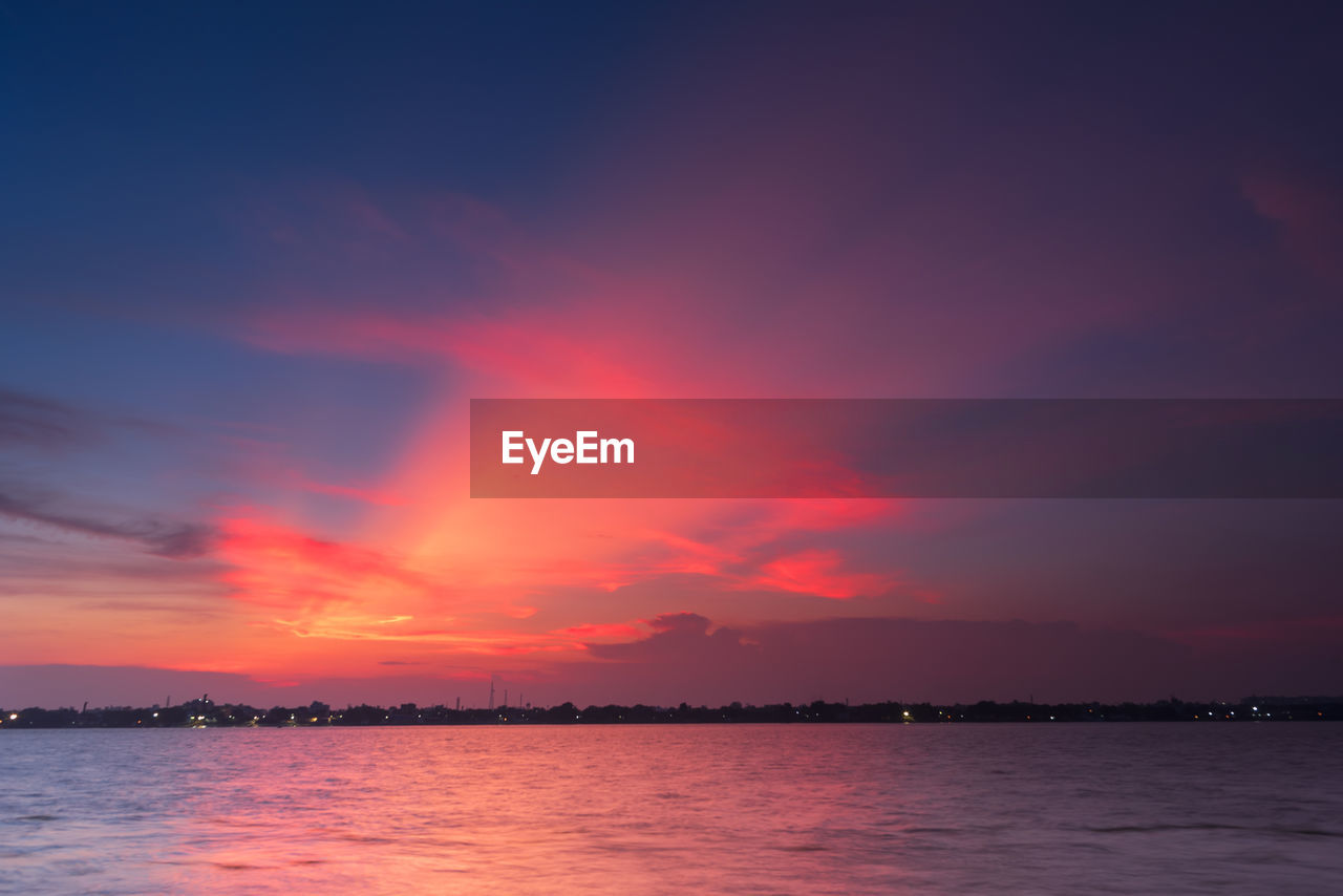 Scenic view of river against romantic sky at sunset