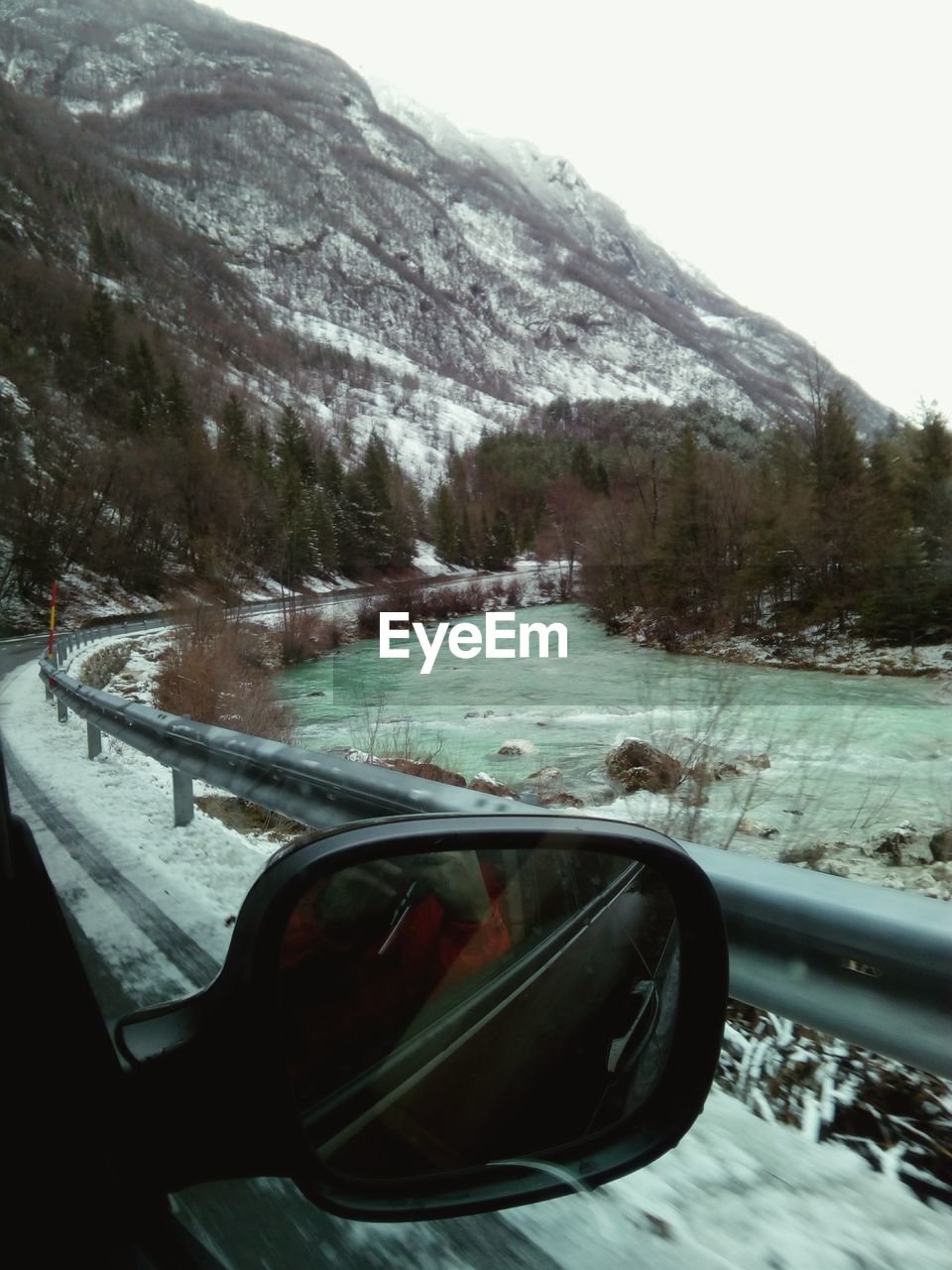 CLOSE-UP OF SNOW ON ROAD AGAINST MOUNTAINS