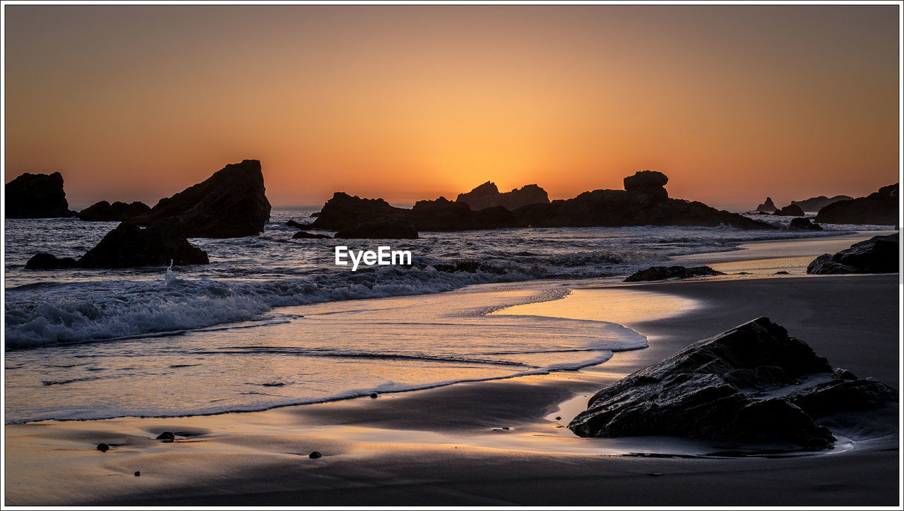SCENIC VIEW OF SEA AGAINST CLEAR SKY AT SUNSET