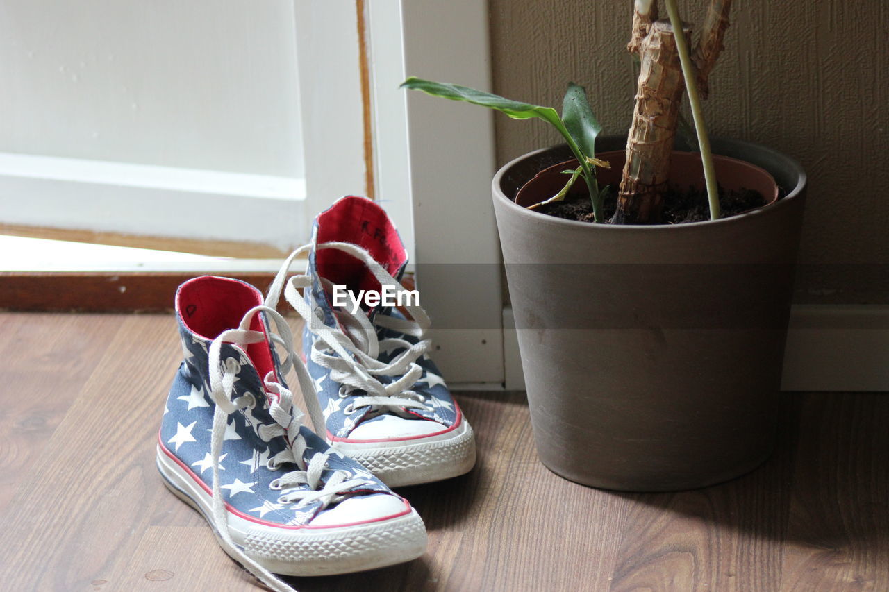 CLOSE-UP OF SHOES ON WOODEN TABLE