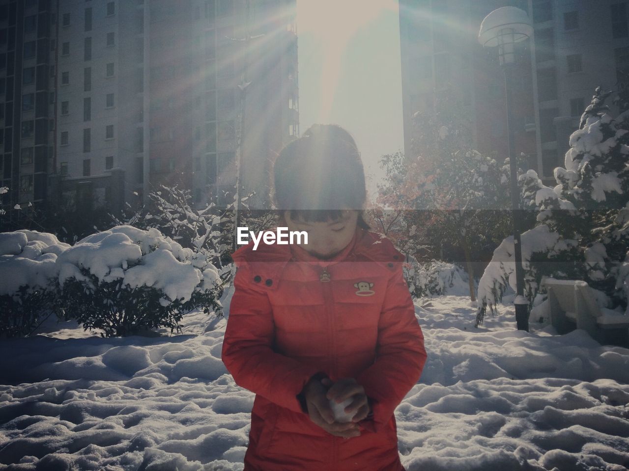 WOMAN COVERING FACE COVERED WITH SNOW