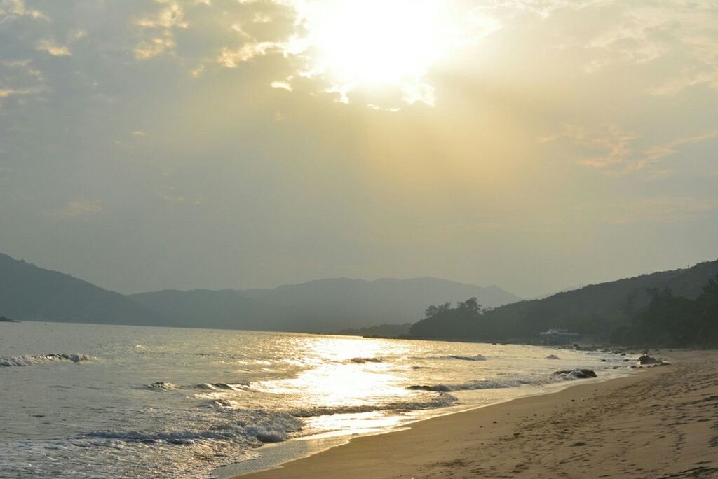 Scenic view of beach against sky on sunny day