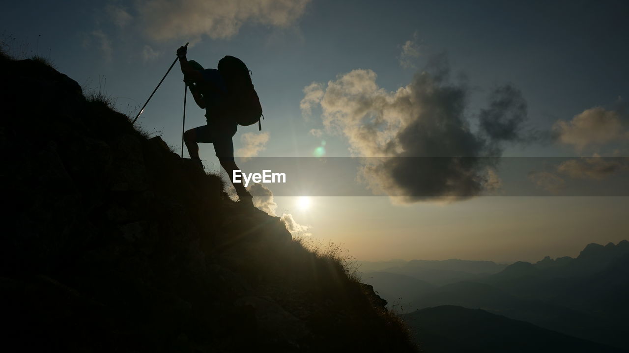 Silhouette man standing on mountain against sky during sunset