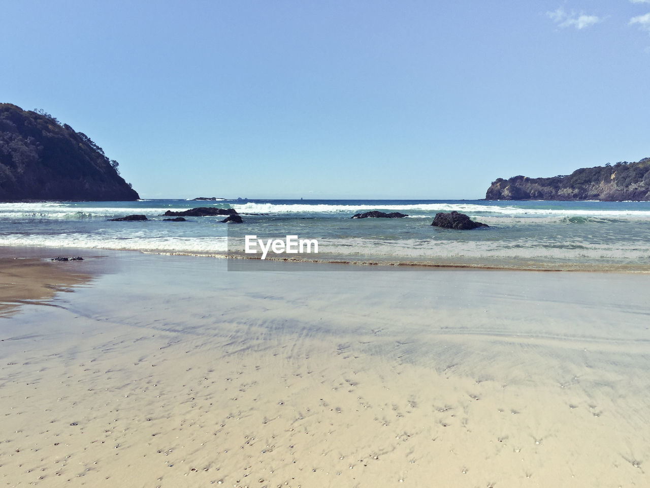 View of calm beach against clear sky