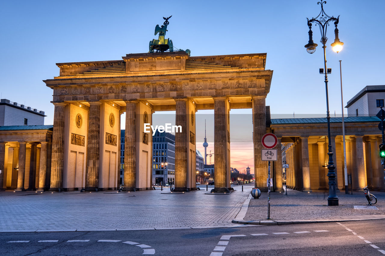 The brandenburg gate with the tv tower in the back at dawn, seen in berlin, germany