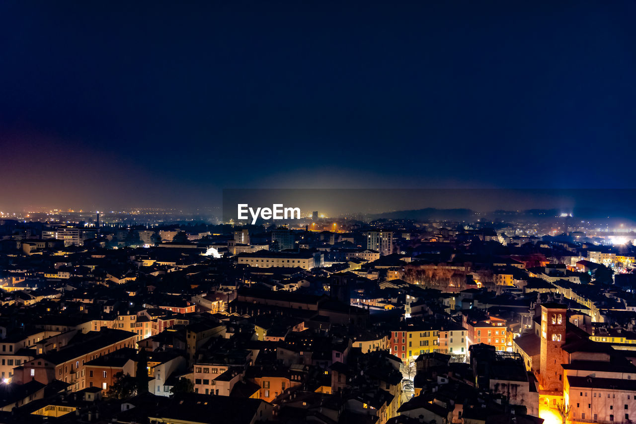 High angle shot of illuminated cityscape against sky at night