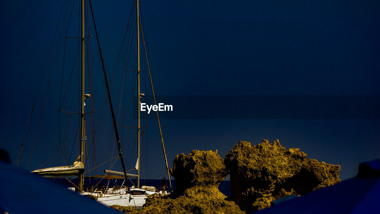 Sailboats in sea against clear blue sky