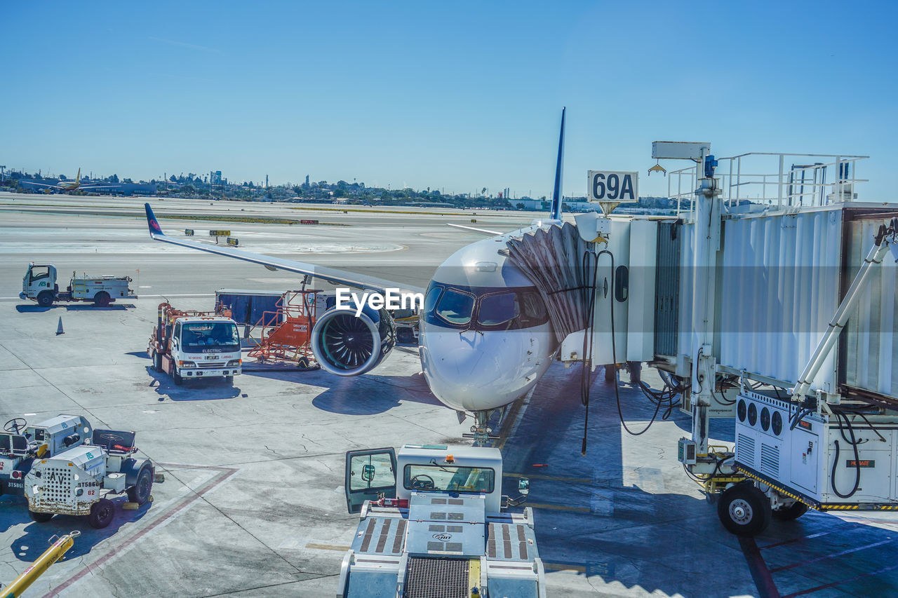 high angle view of airplane on airport runway against clear sky