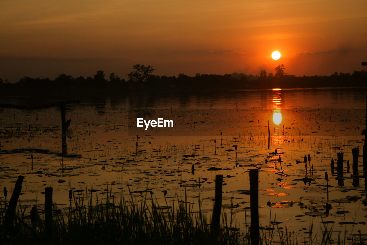 Scenic view of lake against orange sky