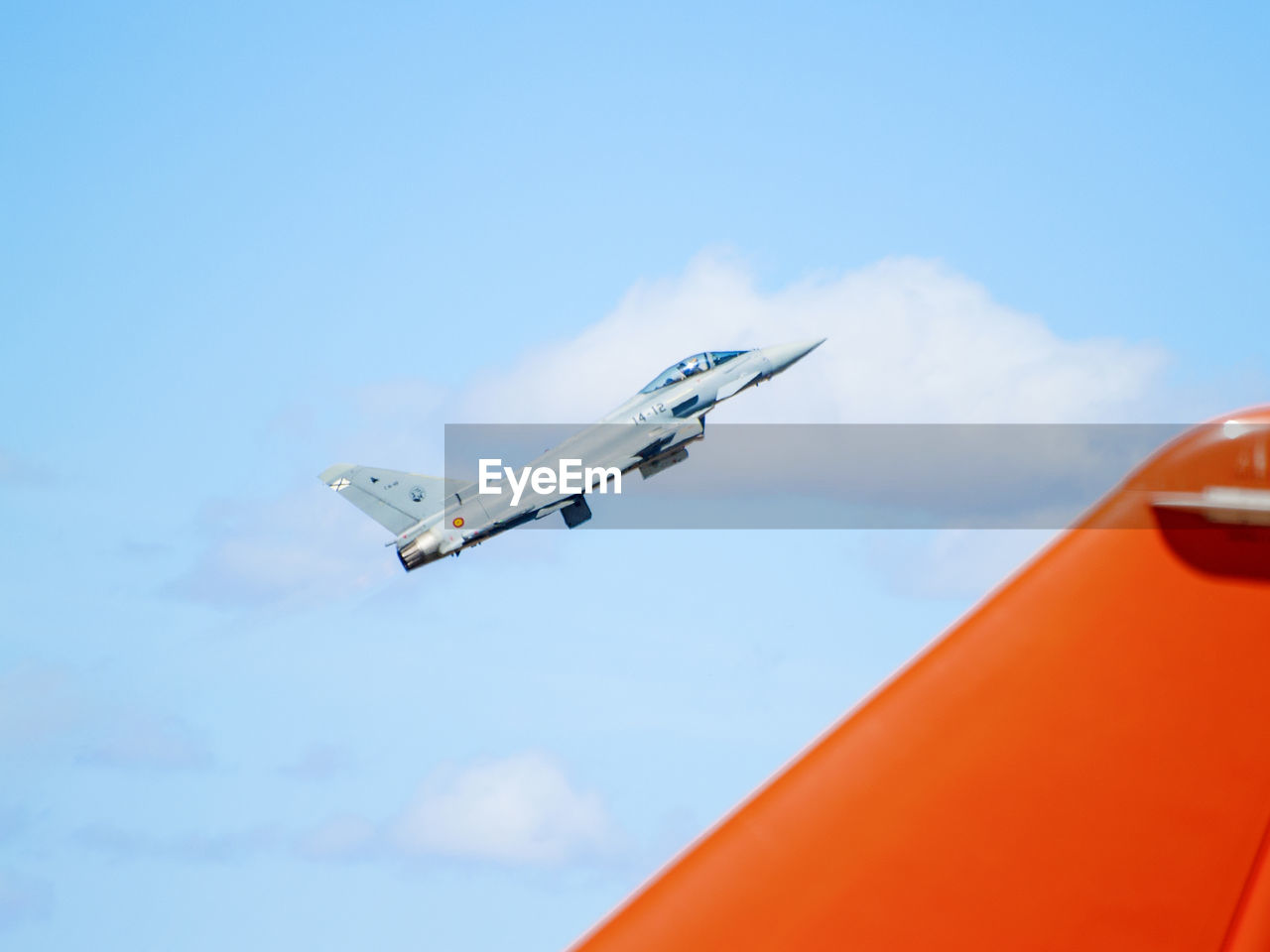 LOW ANGLE VIEW OF AIRPLANE WING AGAINST CLOUDY SKY