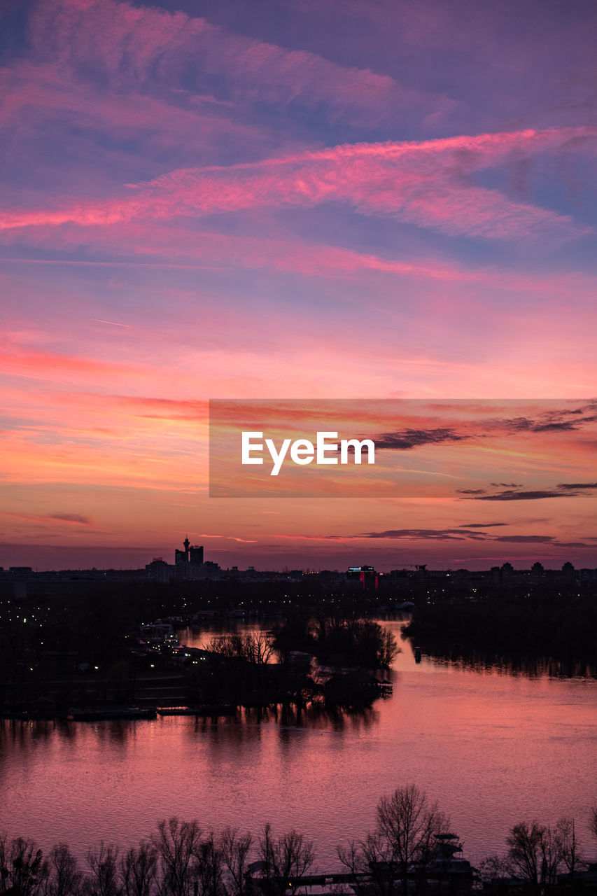 SCENIC VIEW OF LAKE AGAINST ORANGE SKY