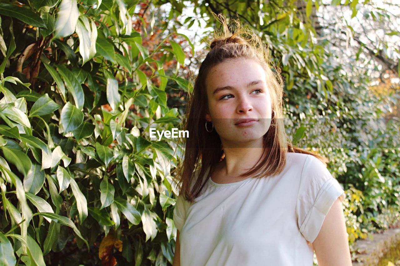 Young woman standing by plants