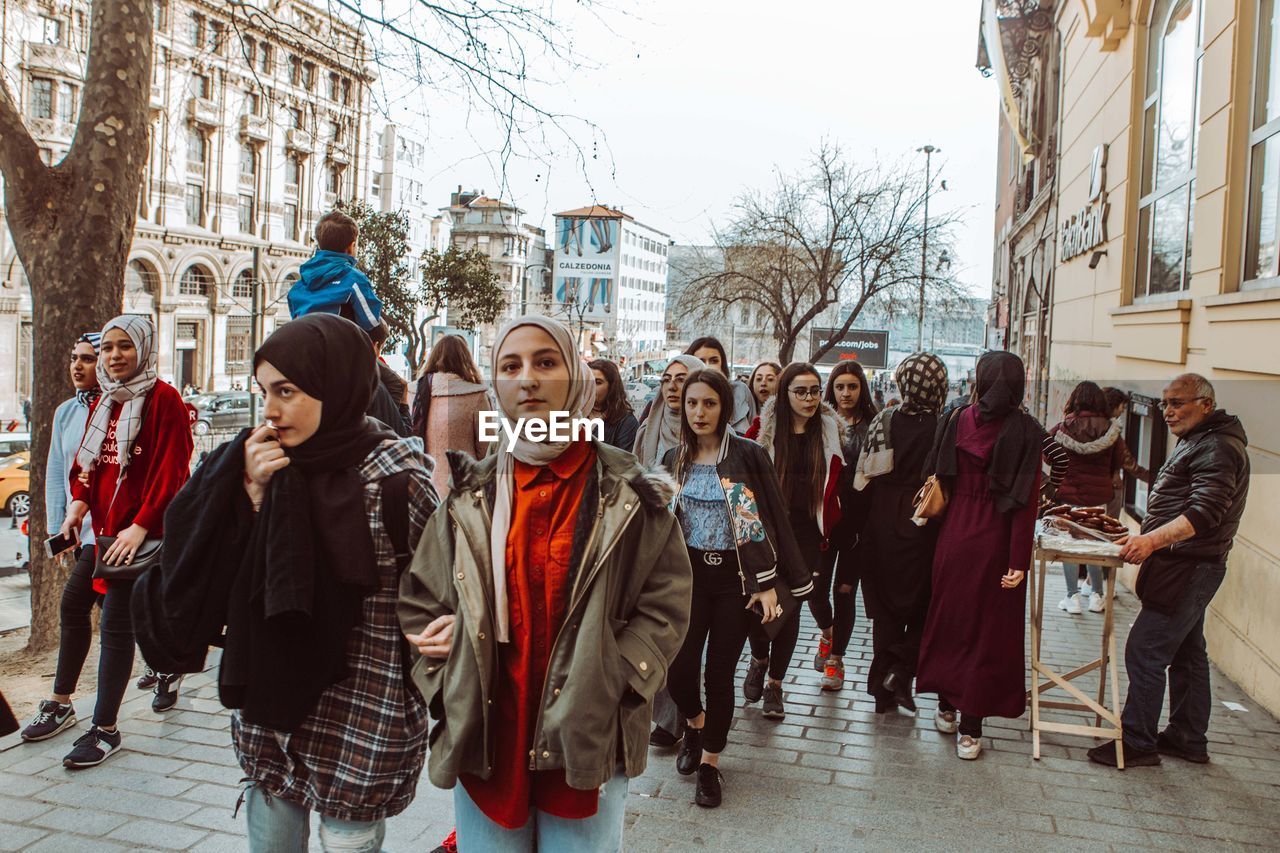 GROUP OF PEOPLE ON STREET IN WINTER