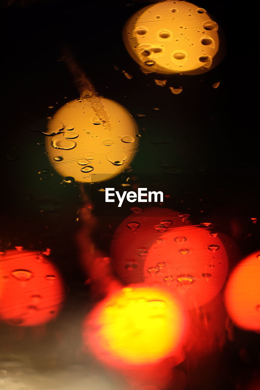 CLOSE-UP OF WATER DROPS ON ILLUMINATED GLASS