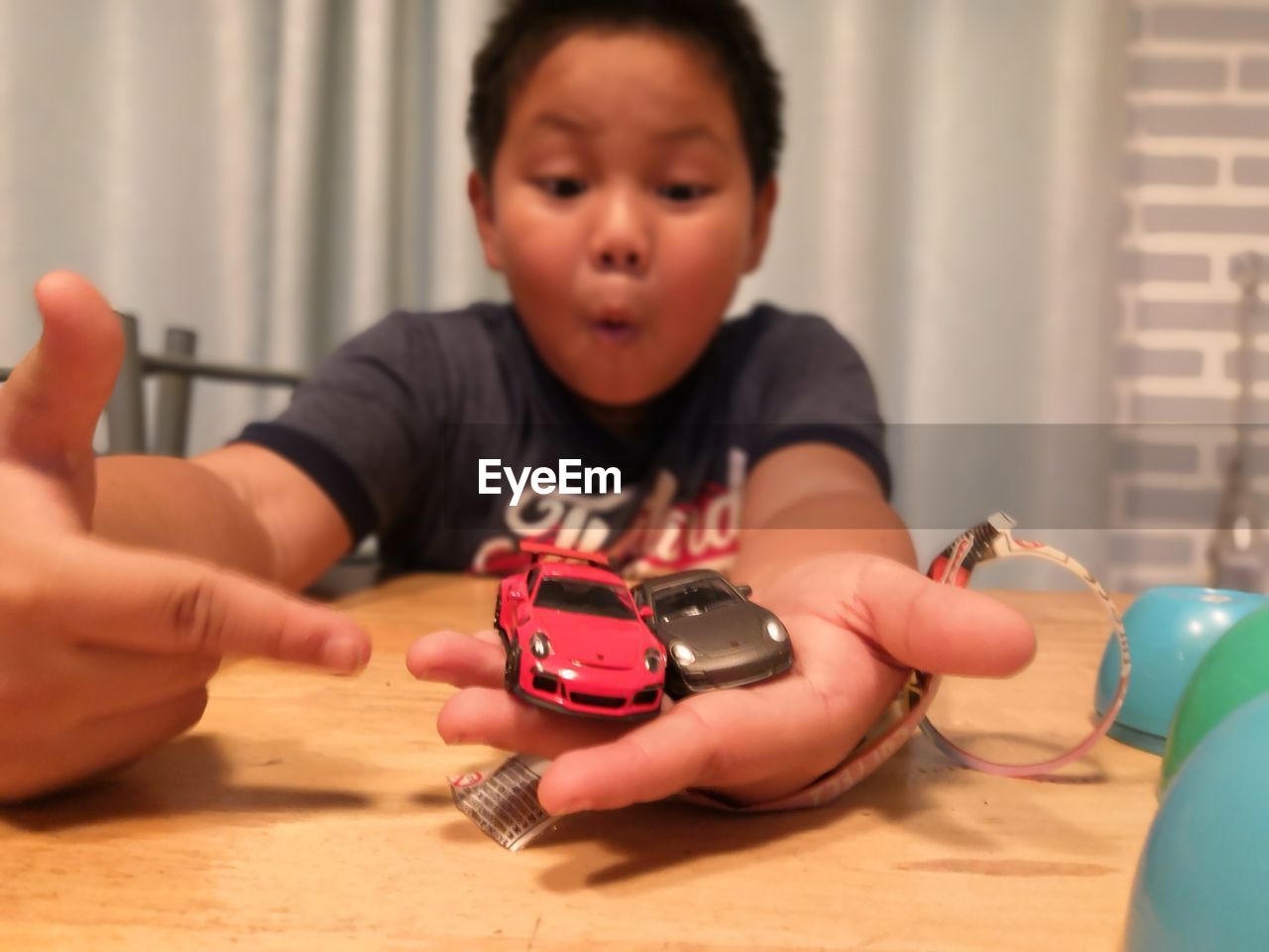 BOY PLAYING WITH TOY ON TABLE