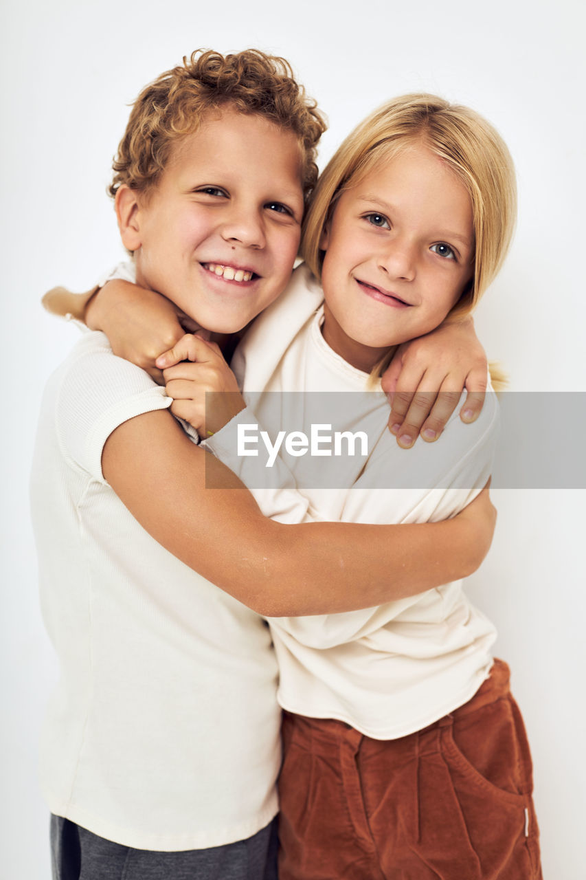 portrait of smiling mother with daughter against white background